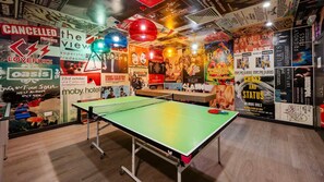 Ein Zimmer mit einem Tischtennisschläger, Wänden mit Postern und einem Holzboden.