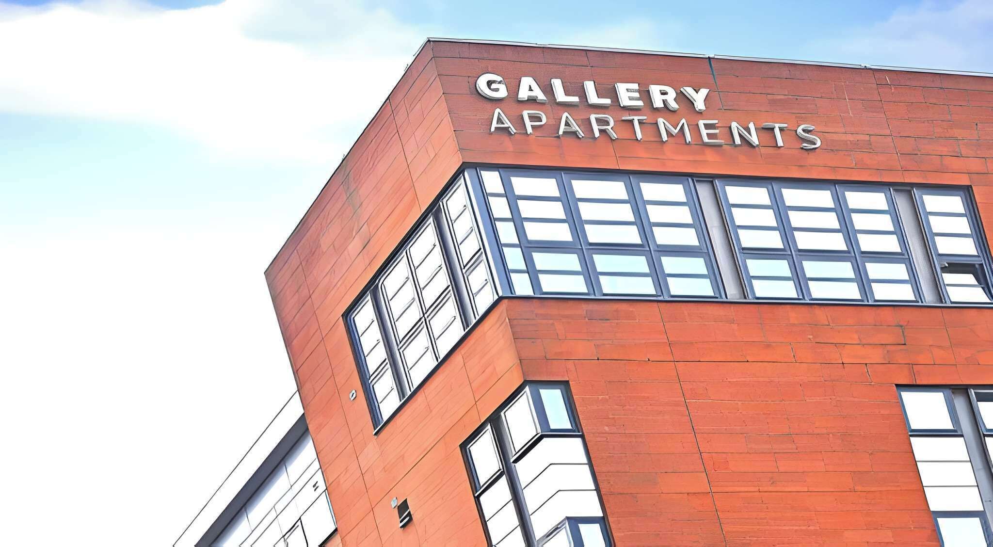 A building with the sign 'GALLERY APARTMENTS' indicating a residential complex.