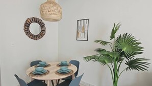 A dining area with a round table, blue chairs, and a large potted plant. - Eden Tropical new 1BR Condo, Walk to Beach ,pool (Punta Cana)