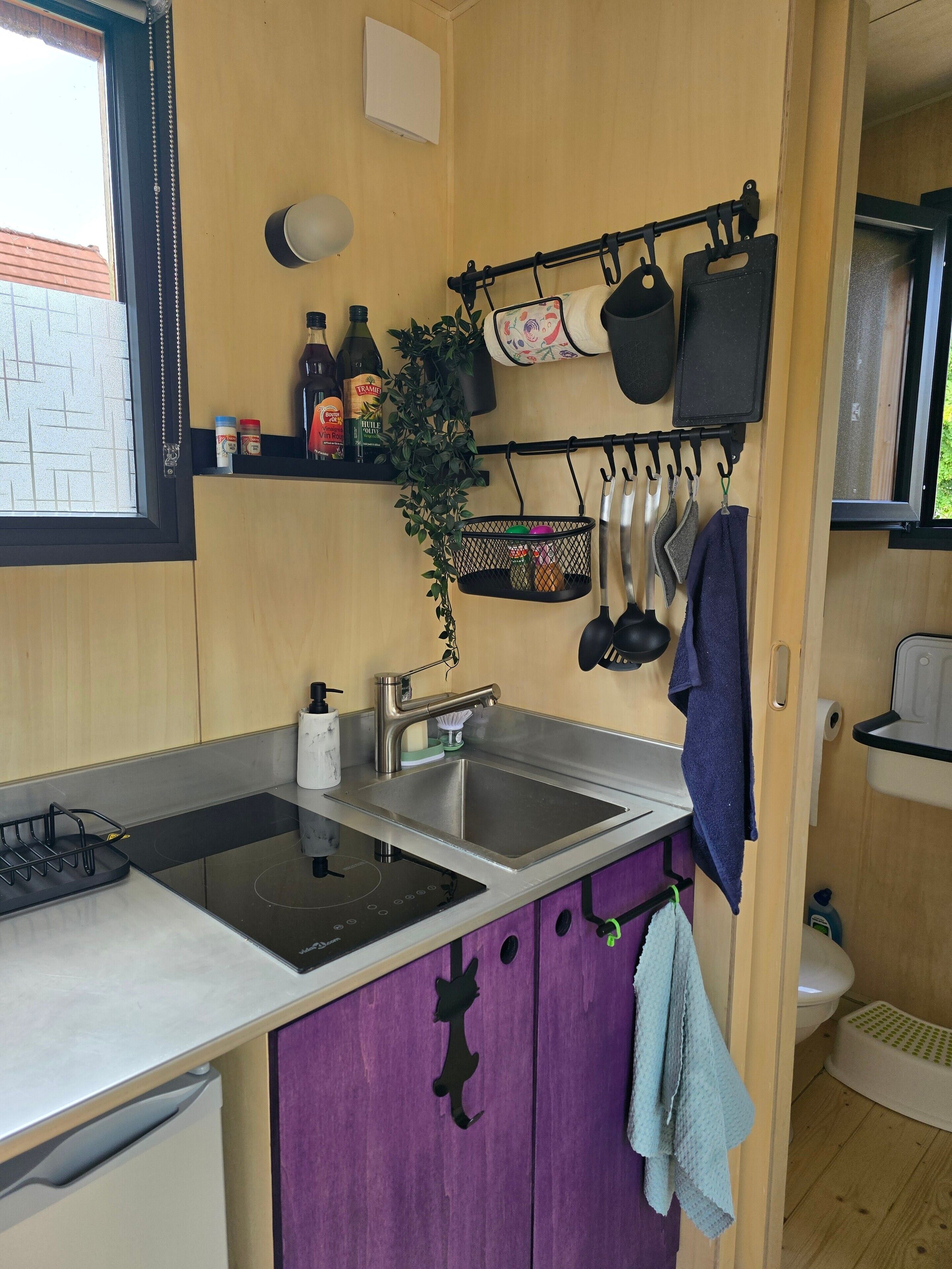 A compact kitchen with a sink, a stove, and a window.