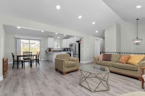 A spacious living area with a dining table, sofas, and a glass coffee table. - 4-bedroom Retreat, AC, free coffee, pet friendly, near shopping in West Jordan (West Jordan)