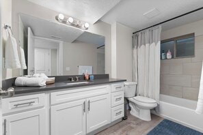 A modern bathroom with a vanity, sink, mirror, and a shower area. - 4-bedroom Retreat, AC, free coffee, pet friendly, near shopping in West Jordan (West Jordan)