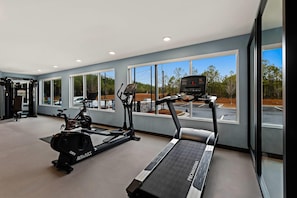 Una palestra con tapis roulant, ellittiche e attrezzi per pesi.