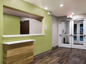 A reception area with a counter, a door, and an exit sign.