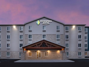 A multi-story hotel with a stone facade, a prominent entrance with a wooden canopy, and a sign reading 'WOODSPRING SUITES'. - Woodspring Suites Rock Hill Charlotte (Rock Hill)