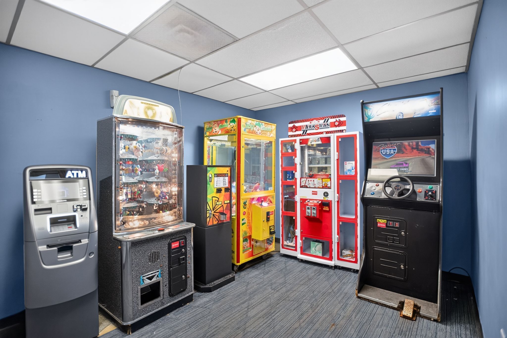 A row of gaming machines in a room with blue walls and a carpeted floor.