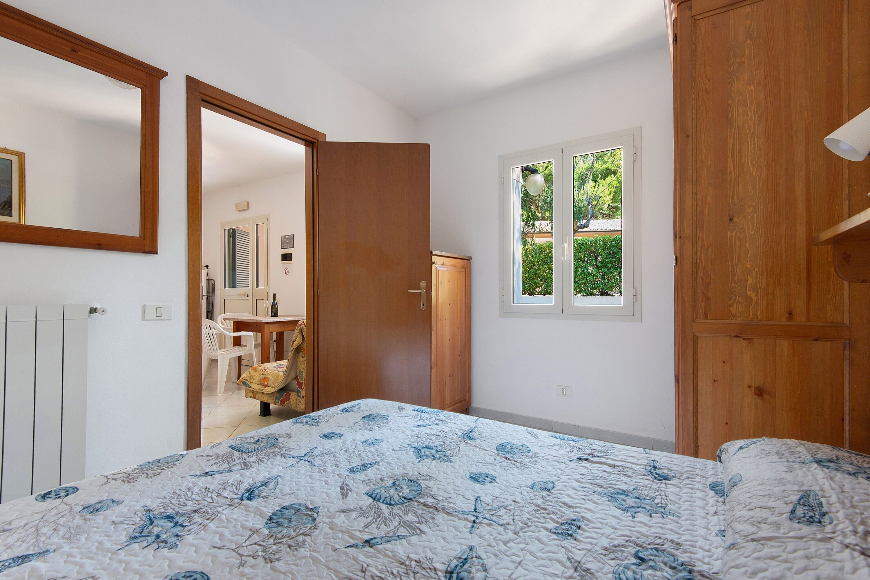 Ein Schlafzimmer mit einem Bett, einem Fenster und einer Tür zu einem Badezimmer.