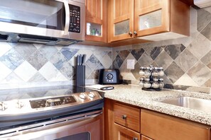 A kitchen with a stainless steel oven, a microwave, a toaster, and a granite countertop. - Ski-In Ski-Out Retreat in the Heart of Mtn Village (Telluride)