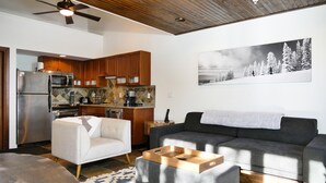 A modern living room with a grey sofa, a white armchair, and a wooden coffee table. - Ski-In Ski-Out Retreat in the Heart of Mtn Village (Telluride)