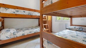 A bunk bed room with a ladder, white walls, and a window with a view of greenery. - Three-Room Apartment with Garden 100 Meters from the Beach - Sole e Mare Tourist Village (Rio)