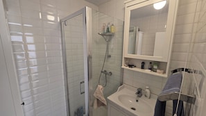 A bathroom with a glass-enclosed shower, a sink, and a mirror above the mirror cabinet. - Bright and spacious 1 bedroom flat near Warren Street. Perfect to explore London (London)