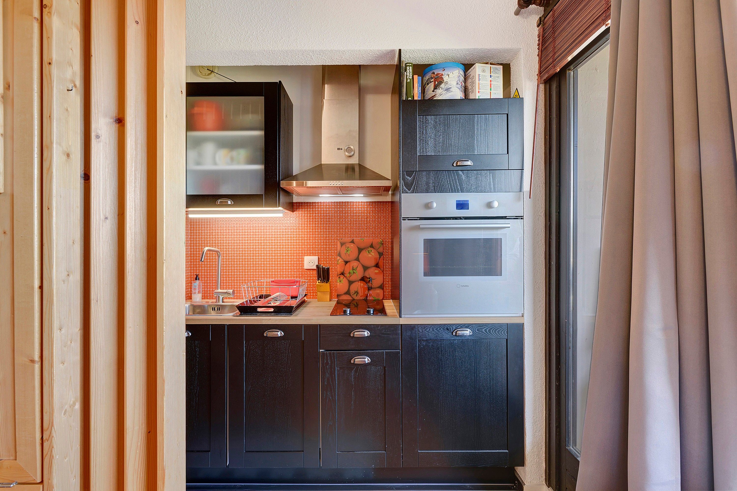 A compact kitchen with a built-in oven, a microwave, and a stove.