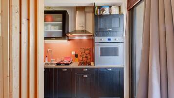 A compact kitchen with a built-in oven, a microwave, and a stove.