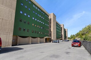 A multi-story building with a green facade and multiple windows.