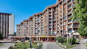Un hôtel à plusieurs étages doté de balcons, d’un espace extérieur aménagé et offrant une vue sur un ciel dégagé.