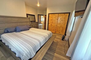 Una camera da letto con un letto, una cassettiera e un armadio in legno.