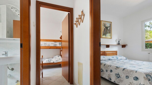 Un dormitorio con una cama doble, una mesita de noche, una ventana con vistas y un cuadro en la pared.