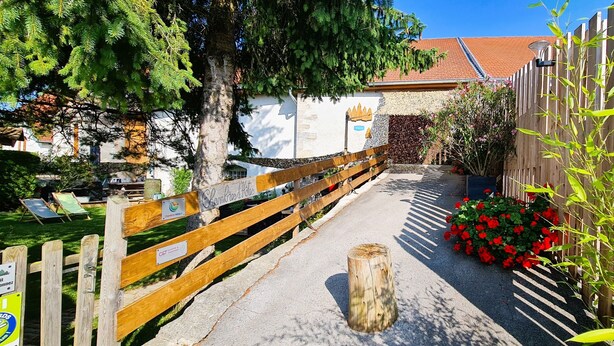 Un chemin menant à un bâtiment entouré d’une clôture en bois, avec une enseigne indiquant qu’il s’agit d’un hôtel.