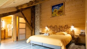 A bedroom with a bed, wooden walls, a painting, and a wooden ceiling. - Épinette Guest Room with Shared Terrace, Garden, and Non-Private Jacuzzi (Vellerot-lès-Vercel)