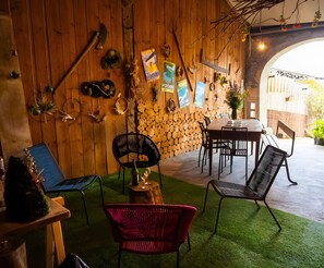 A rustic interior with wooden walls, a dining area, and outdoor seating. - “Agathis” Guest Room with Shared Terrace, Garden, and Non-Private Jacuzzi (Vellerot-lès-Vercel)