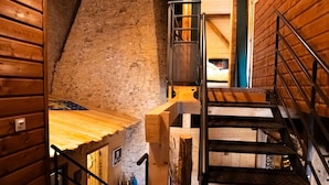 Interior de madera con una escalera que sube a una zona superior.