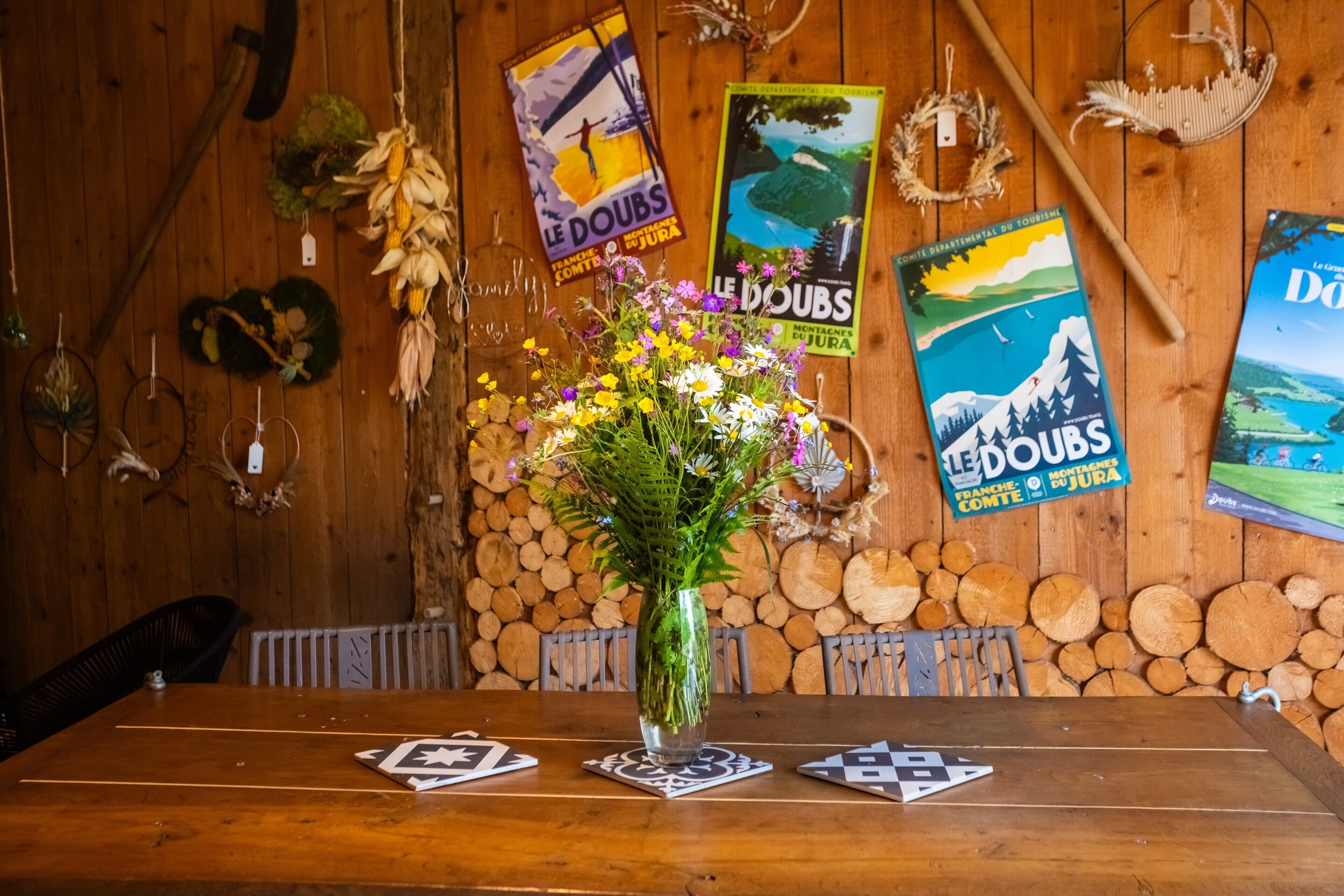 Une table en bois ornée d’un vase de fleurs et d’un jeu de cartes.