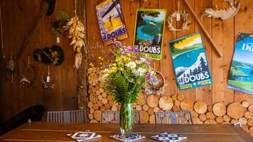 Ein Holztisch mit einem Blumenstrauß, umgeben von Postern an einer Holzwand.