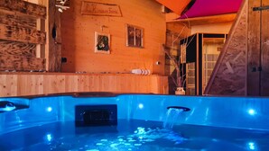 A hot tub with a wooden interior and a wooden wall with a sign.