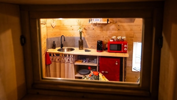 A compact kitchenette with a sink, a red microwave, and a coffee maker. - Guest Room “La Cabane et Spa Chez Jules” with Private Space and Wi-Fi (Vellerot-lès-Vercel)
