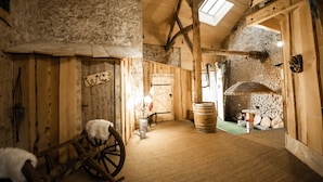 A rustic interior with wooden walls, a thatched roof, a wooden cart, and a barrel. - Guest Room “La Cabane et Spa Chez Jules” with Private Space and Wi-Fi (Vellerot-lès-Vercel)