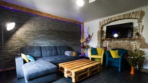 A modern living room with a sectional sofa, a coffee table, and two armchairs. - Gîte Chez Jules with Spa, Private Terrace, and Wi-Fi (Vellerot-lès-Vercel)