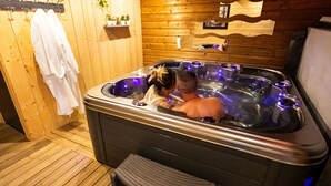 A wooden room with a hot tub, towels, and a shelf with plants. - Gîte Chez Jules with Spa, Private Terrace, and Wi-Fi (Vellerot-lès-Vercel)