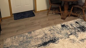 A dining area with a round table and chairs, a door, a window with blinds, and a carpet. - Cozy 1-bedroom apartment in marvelous Glen Elder with AC (Glen Elder)