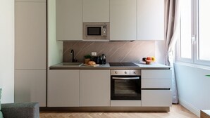 A modern kitchen with a built-in microwave, oven, and a small sink. - Incanto 107 - My Home in Como (Como)