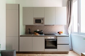 A modern kitchen with a built-in microwave, oven, and a small sink. - Incanto 107 - My Home in Como (Como)