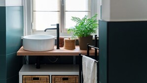 A bathroom with a white sink, a potted plant, and wicker baskets. - Incanto 107 - My Home in Como (Como)
