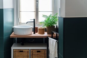 A bathroom with a white sink, a potted plant, and wicker baskets. - Incanto 107 - My Home in Como (Como)