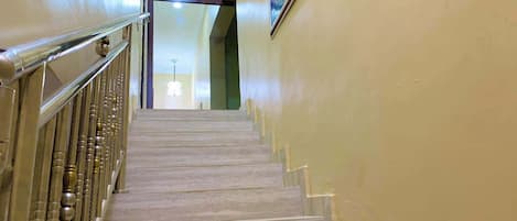 Una escalera con barandilla y una lámpara en la parte superior.