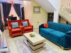 A living room with two sofas, a coffee table, and a staircase.