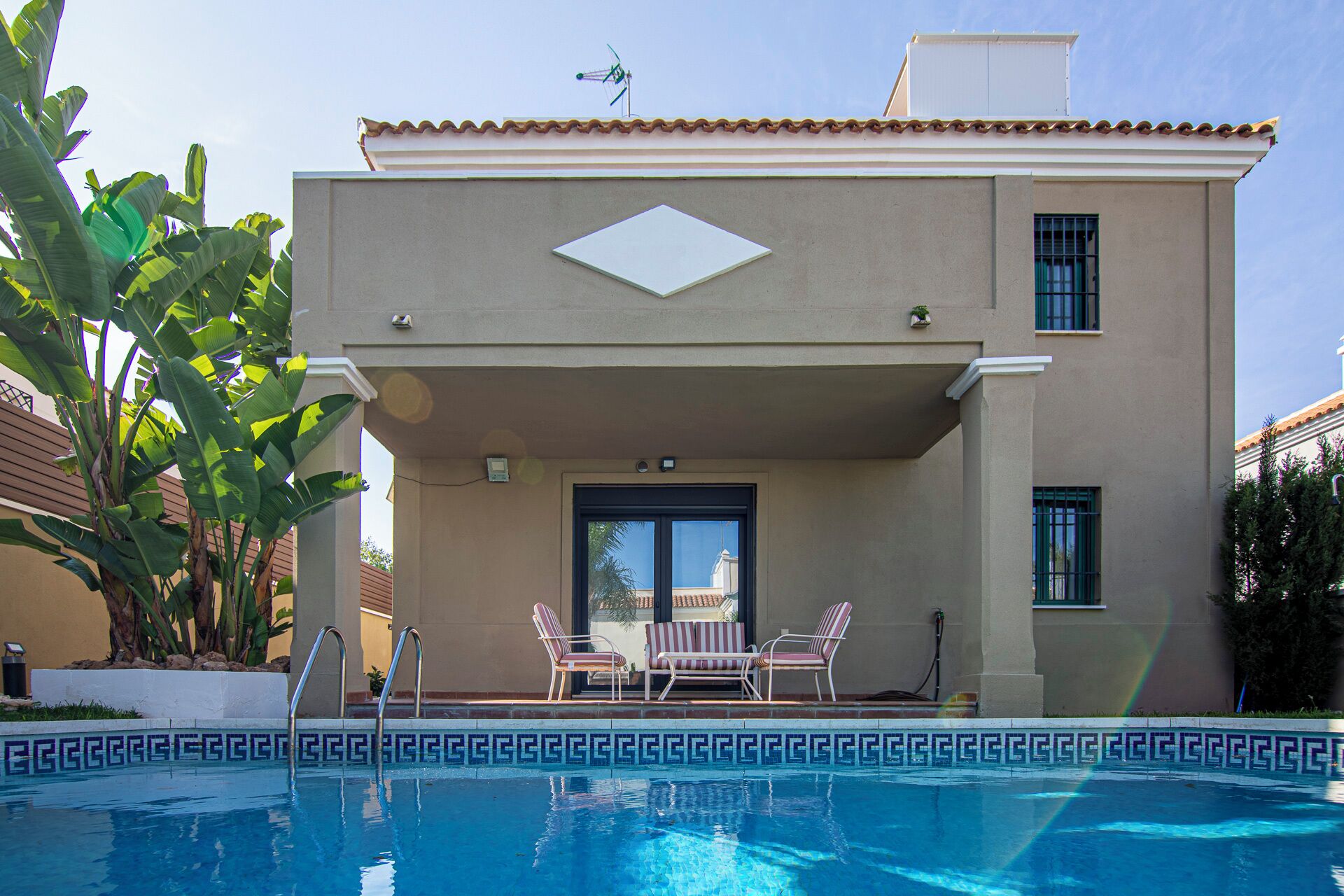 A two-story building with a swimming pool in front.