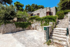A stone building with a staircase leading to a flat roof, surrounded by greenery. - Villa Natura by BarbarHouse (Santa Cesarea Terme)