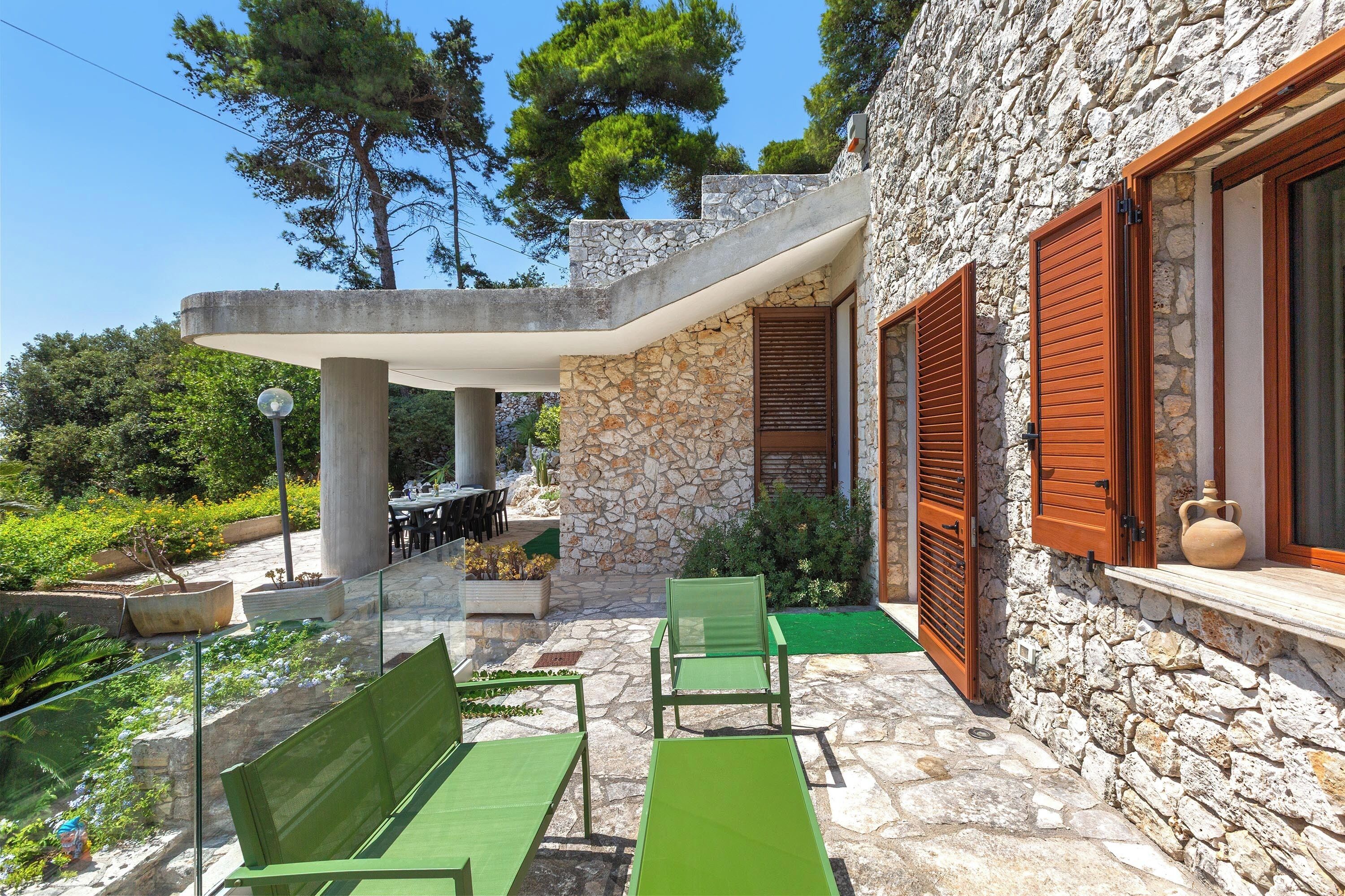 A stone building with a patio area featuring outdoor furniture and a table.