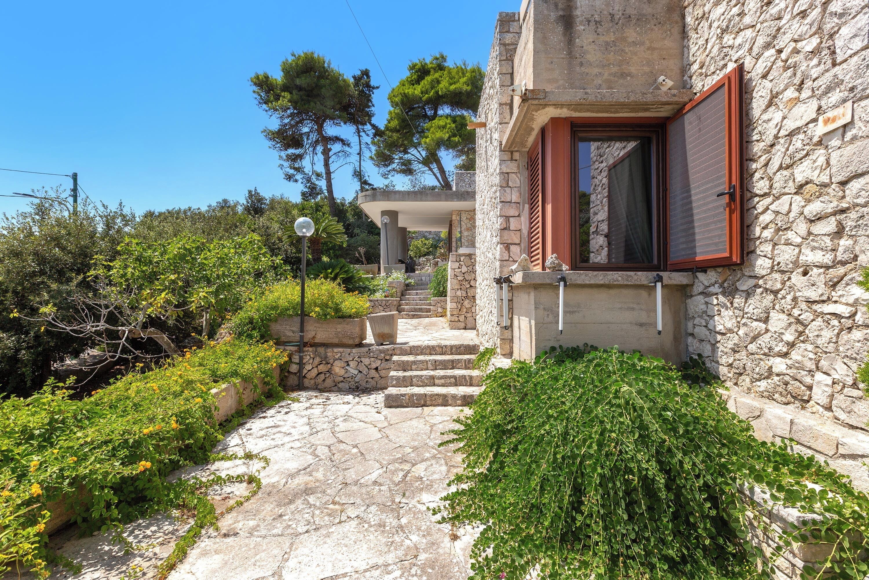 A stone building with a staircase leading to a wooden door.