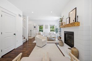 A modern living room with a fireplace, white furniture, and a view of the outdoors. - It's A Wonderful Life - Union Pier, MI (New Buffalo)