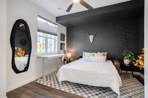 A bedroom with a bed, a desk, a mirror, and a window. - Stylish Denver Retreat Townhome (Denver)