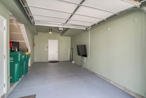 A garage with a concrete floor, a white door, and a ceiling fan. - Stylish Denver Retreat Townhome (Denver)