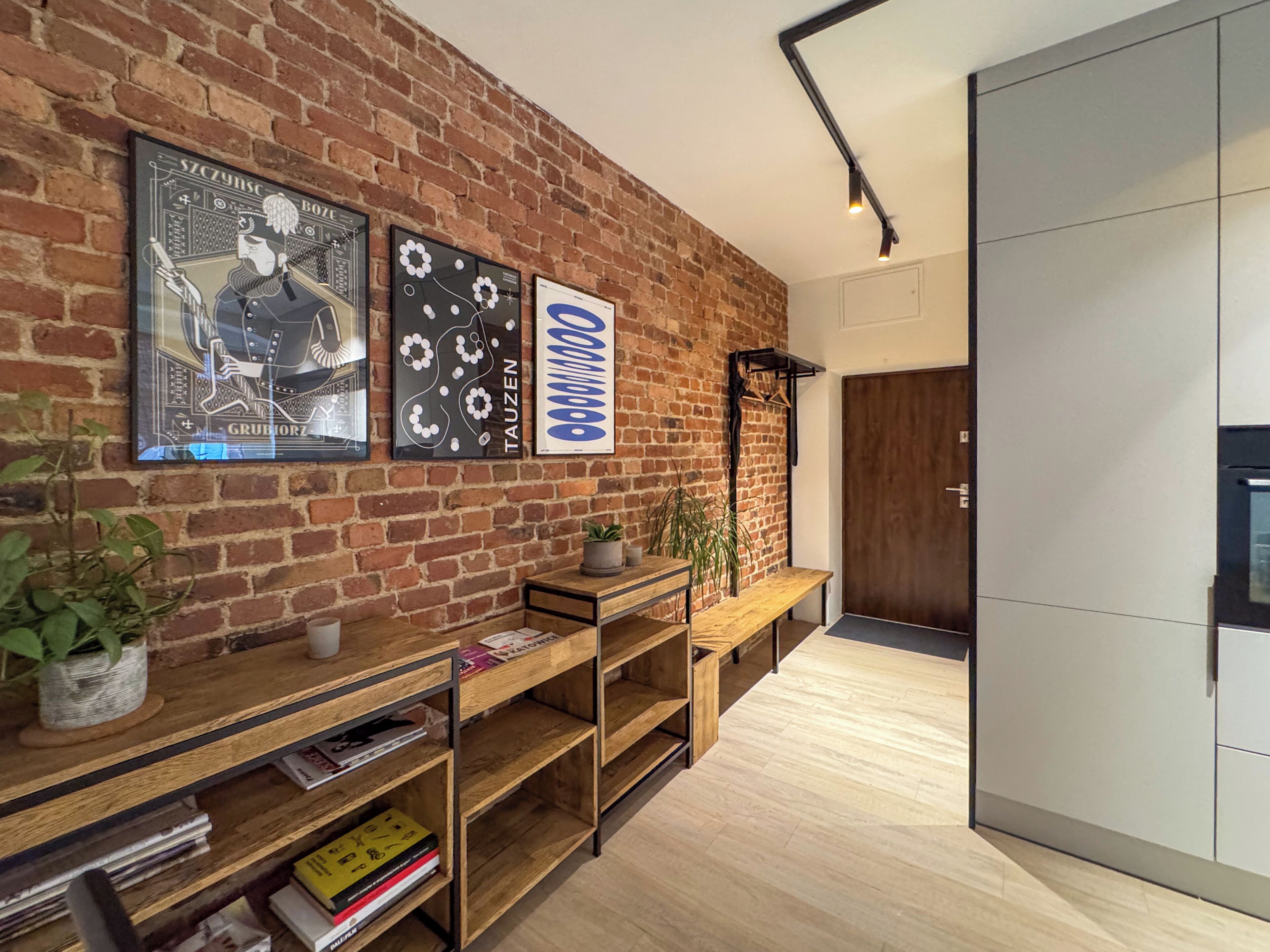 Un interior moderno con pared de ladrillo, estantes de madera y una puerta.