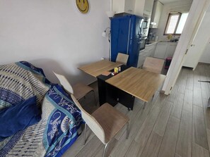 A compact living space with a sofa, a dining table, and a kitchenette.
