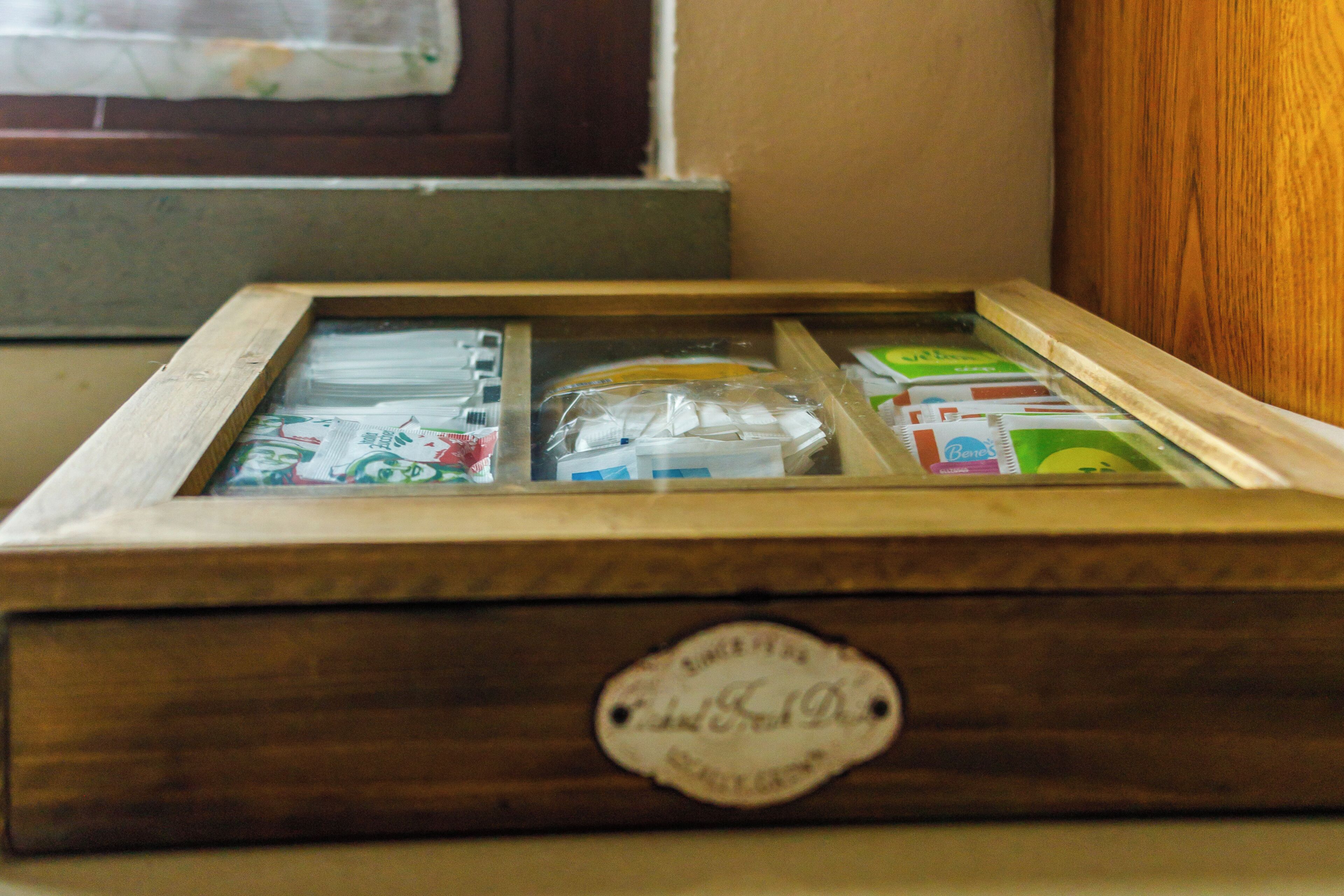 Una caja de madera con frente de vidrio que contiene varios objetos, incluyendo una bolsa de plástico y documentos.