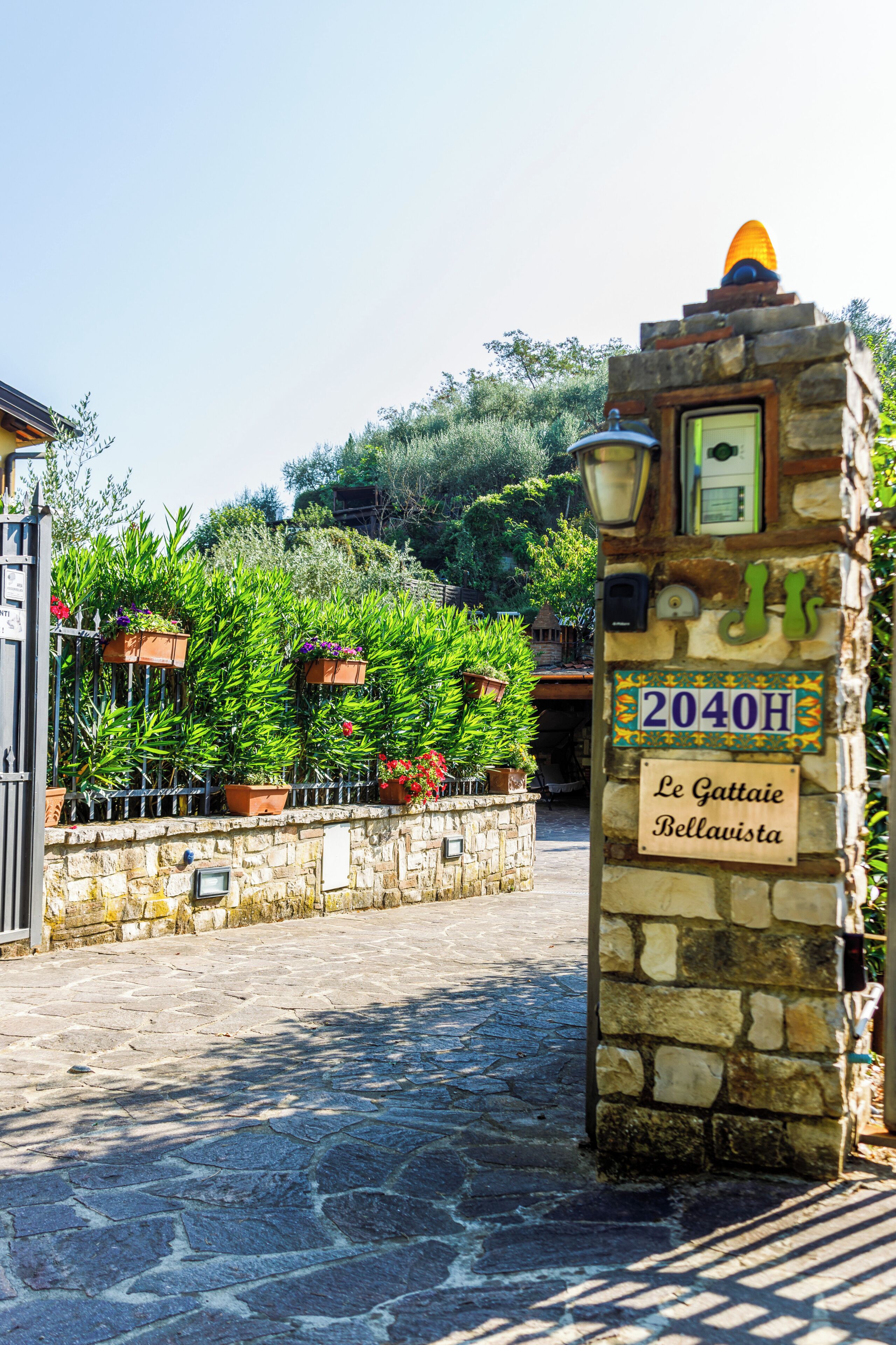 Une entrée en pierre surmontée d’une enseigne indiquant « Le Gattaie Bellavista » et d’un numéro de maison, le « 2040H ».